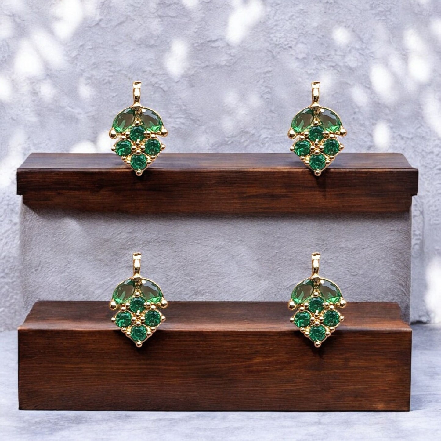 Leaf pendant encrusted with sparkling green American Diamond (AD) stones, featuring metallic detailing for a refined and graceful jewelry design.