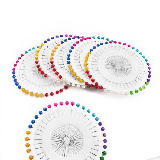 Metal head pins featuring smooth, glossy pearl tops, ideal for securing fabric, designing jewelry, or decorative craft projects.