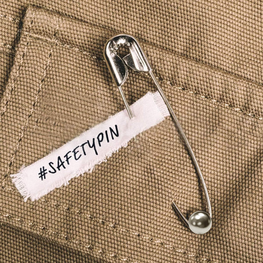 Metal safety pin with a pointed tip and locking clasp, ideal for sewing, clothing adjustments, or craft projects.