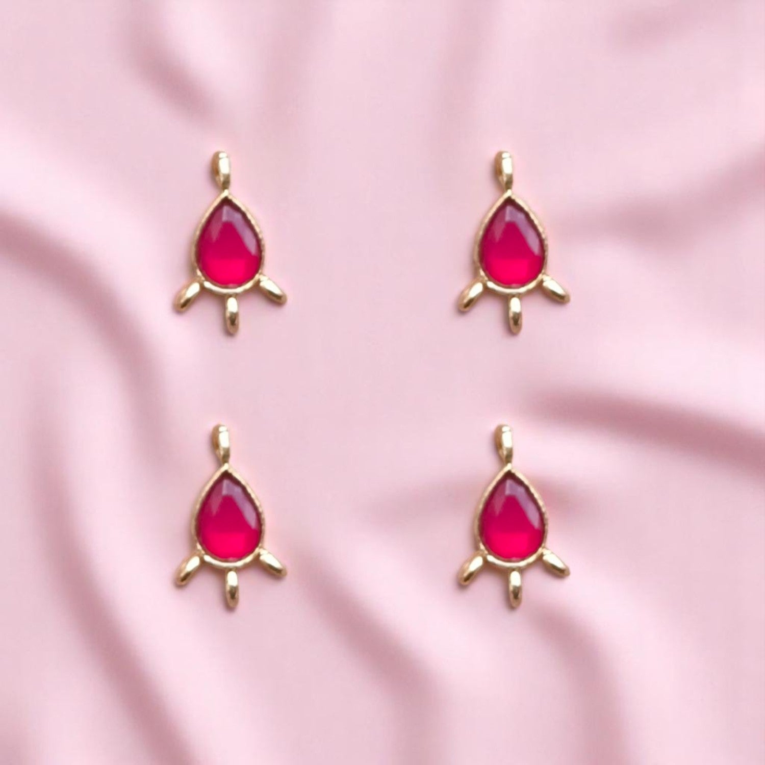 Elegant red-colored Kundan drop connectors with teardrop shapes and metallic gold frames, perfect for linking elements in necklaces, earrings.