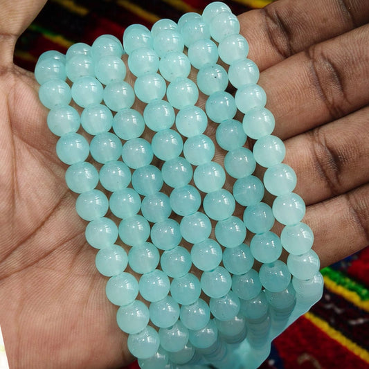 Hand holding Ocean Blue Jelly beads, showcasing their vibrant blue color and glossy jelly-like texture