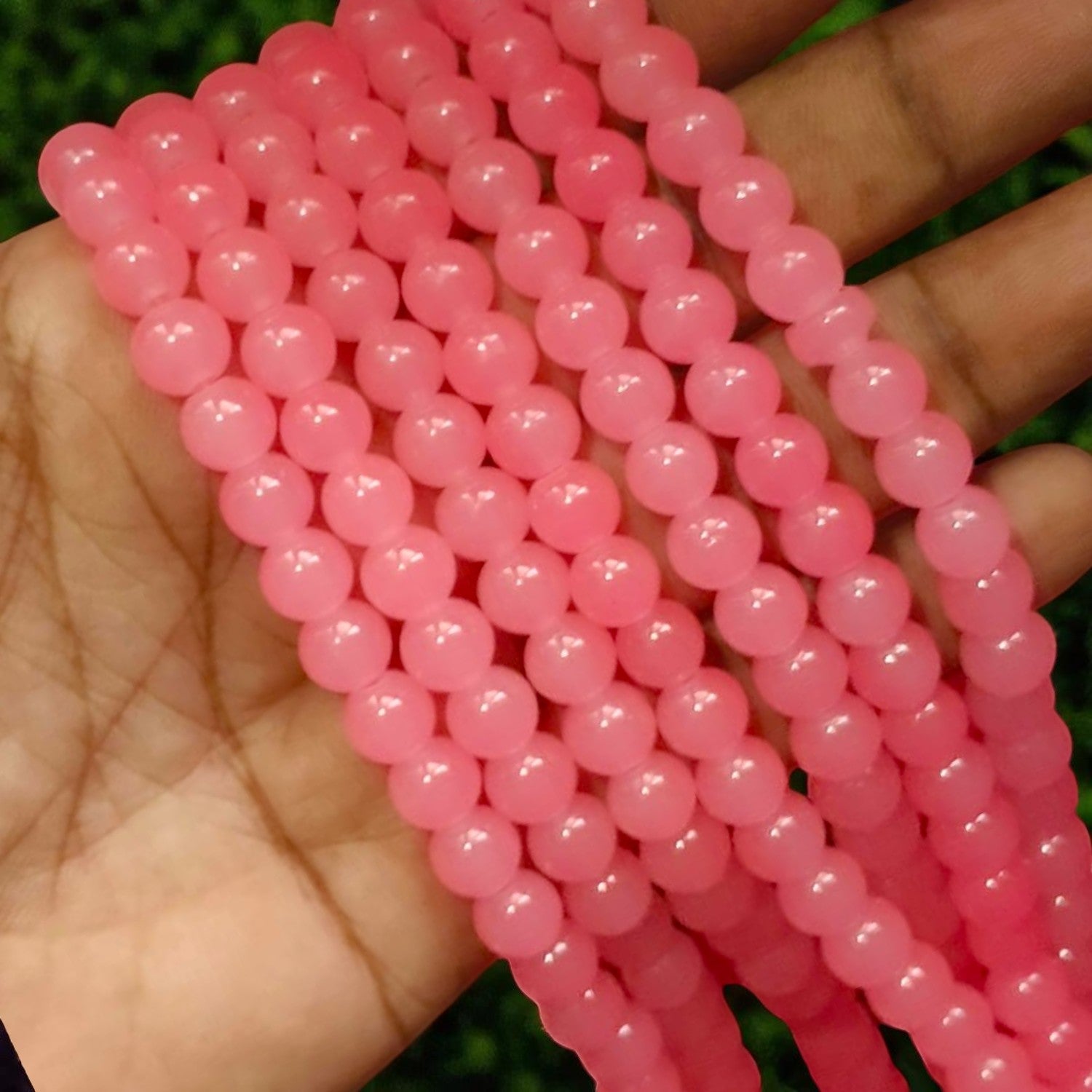 Round jelly beads in soft pink and peach tones with a shiny, semi-transparent appearance, perfect for bracelets, necklaces, and creative beading projects.