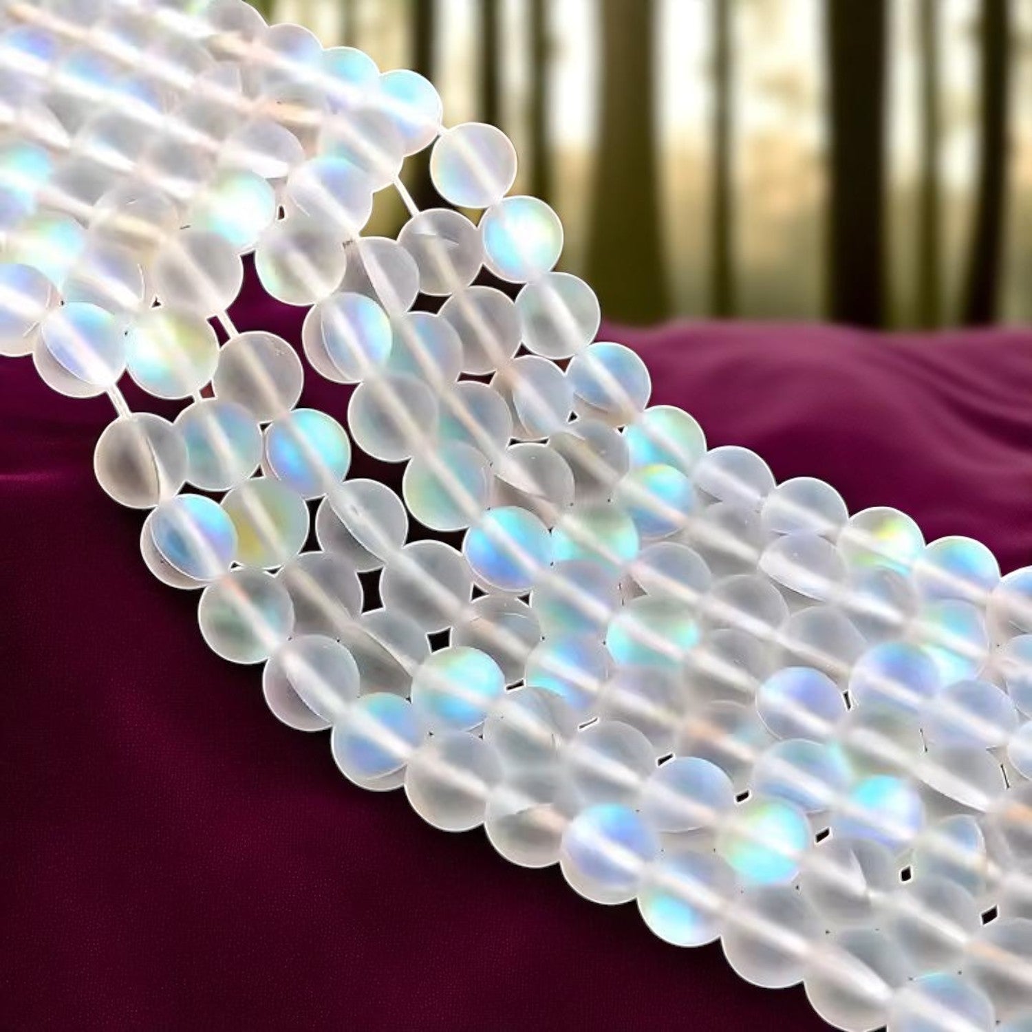 Iridescent aura beads with a matte finish, reflecting rainbow-like colors, ideal for jewelry and craft projects.